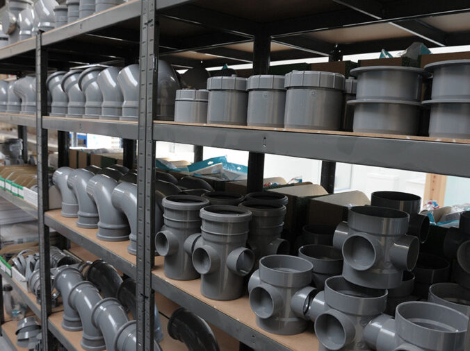 grey PVC fittings on a shelf in a commercial plumbing warehouse