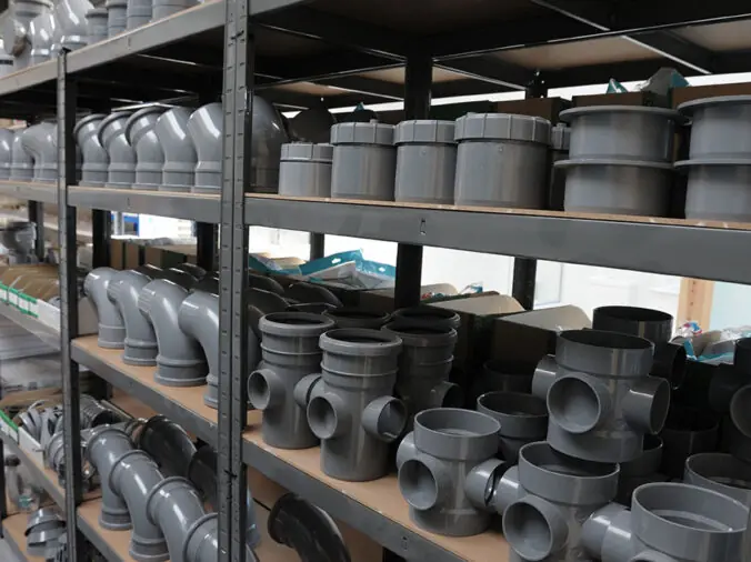 grey PVC fittings on a shelf in a commercial plumbing warehouse