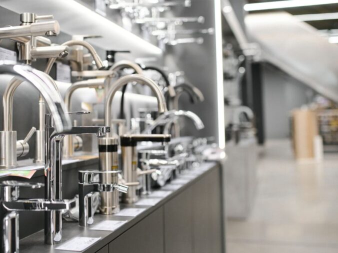 kitchen sink faucets on display in a kitchen and bath showroom